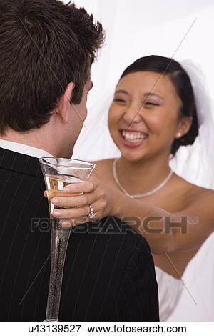 USA, Illinois, Metamora, Bride and groom embracing with champagne View Large Photo Image Stock Photo - USA, Illinois, Metamora, Bride and groom embracing with champagne. Fotosearch