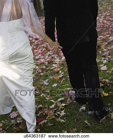 USA, Illinois, Metamora, Bride and groom holding hands View Large Photo Image Stock Photo - USA, Illinois, Metamora, Bride and groom holding hands. Fotosearch