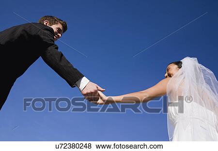 USA, Illinois, Metamora, Bride and groom holding hands View Large Photo Image Stock Photo - USA, Illinois, Metamora, Bride and groom holding hands. Fotosearch
