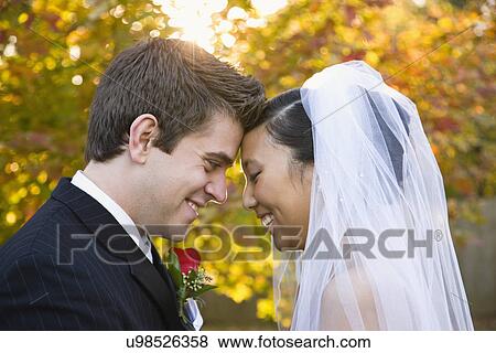 Stock Photo - USA, Illinois, Metamora, Bride and groom laughing. Fotosearch