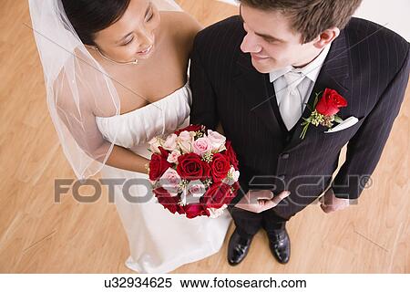 Stock Photography - USA, Illinois, Metamora, Bride and groom arm in arm. Fotosearch