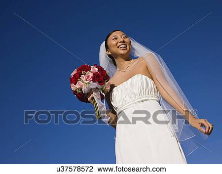 Stock Image - USA, Illinois, Metamora, Bride holding bouquet. Fotosearch
