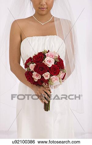 Stock Photograph - USA, Illinois, Metamora, Bride holding bouquet. Fotosearch