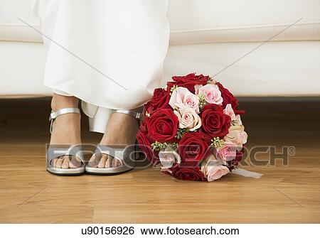 USA, Illinois, Metamora, Bride sitting on sofa beside bouquet View Large Photo Image Stock Photograph - USA, Illinois, Metamora, Bride sitting on sofa beside bouquet. Fotosearch