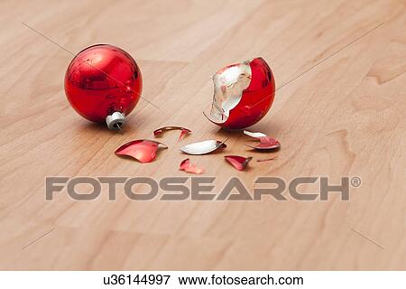 Stock Photo - USA, Illinois, Metamora, Broken red Christmas baubles on floor. Fotosearch
