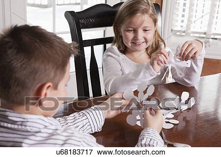 USA, Illinois, Metamora, brother (8-9) and sister (6-7) making paper cutouts View Large Photo Image Stock Photo - USA, Illinois, Metamora, brother (8-9) and sister (6-7) making paper cutouts. Fotosearch