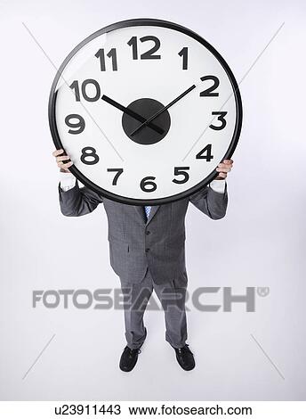 USA, Illinois, Metamora, Business man holding large clock over head View Large Photo Image Stock Image - USA, Illinois, Metamora, Business man holding large clock over head. Fotosearch