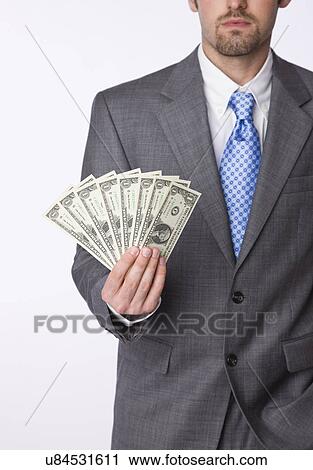 Stock Image - USA, Illinois, Metamora, Business man holding dollar bills. Fotosearch