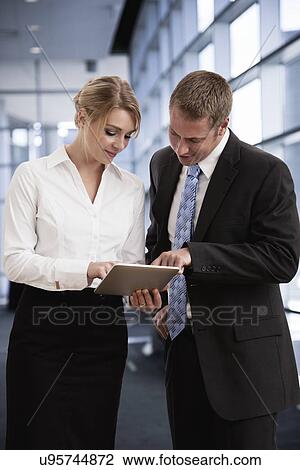 Stock Image - USA, Illinois, Metamora, Business man and woman using tablet pc. Fotosearch