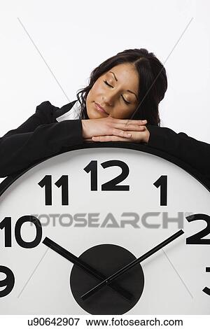Stock Photo - USA, Illinois, Metamora, Business woman resting on large clock. Fotosearch