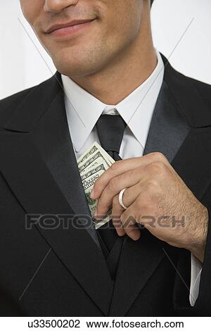 Stock Image - USA, Illinois, Metamora, Businessman taking out money from jacket. Fotosearch