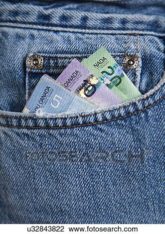 Stock Image - USA, Illinois, Metamora, Canadian banknotes in front pocket of blue jeans. Fotosearch