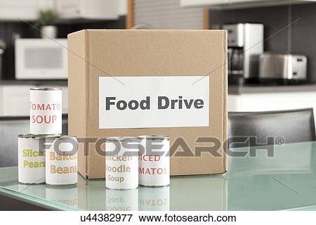 Stock Photo - USA, Illinois, Metamora, Cardboard box and canned food in kitchen. Fotosearch