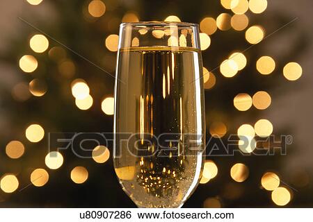 USA, Illinois, Metamora, Champagne in glass with defocused Christmas tree in background View Large Photo Image Stock Photograph - USA, Illinois, Metamora, Champagne in glass with defocused Christmas tree in background. Fotosearch