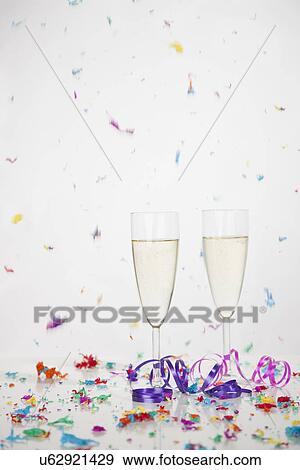 Stock Photo - USA, Illinois, Metamora, Champagne flutes with falling confetti. Fotosearch