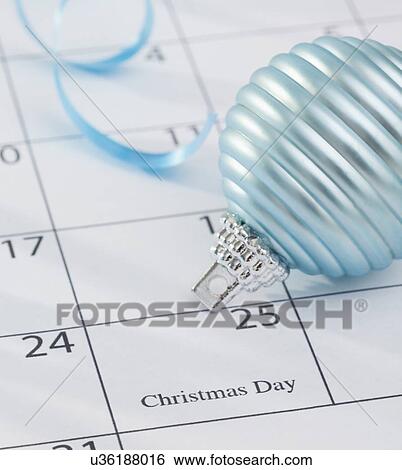 Stock Photograph - USA, Illinois, Metamora, Christmas bulb laying on calendar. Fotosearch