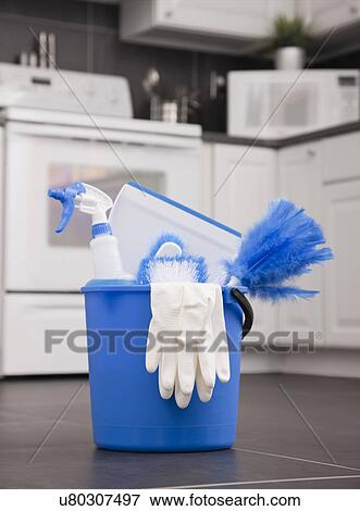 Stock Photo - USA, Illinois, Metamora, cleaning equipment in bucket on kitchen floor. Fotosearch