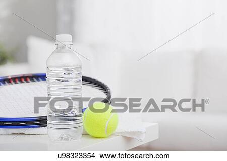Picture - USA, Illinois, Metamora, Close up of tennis rocket, tennis ball and water bottle on table. Fotosearch