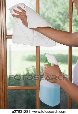 Stock Image - USA, Illinois, Metamora, Close-up of woman cleaning window. Fotosearch