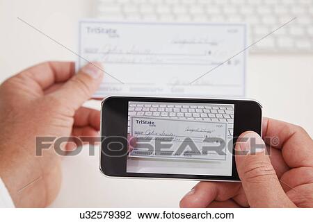 Stock Image - USA, Illinois, Metamora, Close-up of man photographing checkup. Fotosearch