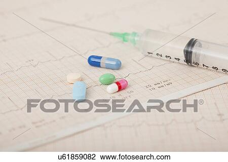 Stock Image - USA, Illinois, Metamora, Close up of medicines and syringe on medical record. Fotosearch