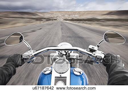Stock Image - USA, Illinois, Metamora, Close up of man's hand on motorcycle handlebars while driving. Fotosearch