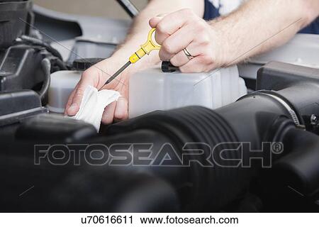 USA, Illinois, Metamora, Close-up of man's hands checking oil level View Large Photo Image Stock Image - USA, Illinois, Metamora, Close-up of man's hands checking oil level. Fotosearch