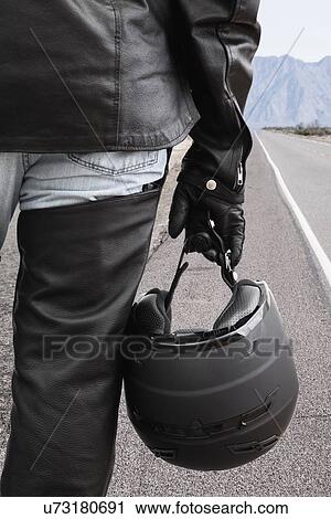 Stock Image - USA, Illinois, Metamora, Close up of motorcycle driver's hand holding helmet. Fotosearch