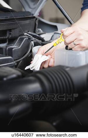 Stock Photo - USA, Illinois, Metamora, Close-up of man's hands checking oil level. Fotosearch