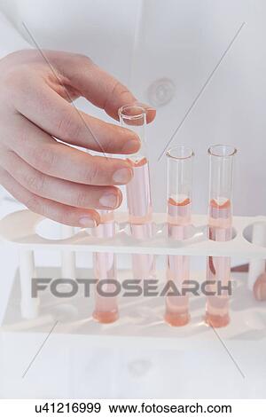 Stock Photo - USA, Illinois, Metamora, close up of woman's hand holding laboratory vials. Fotosearch