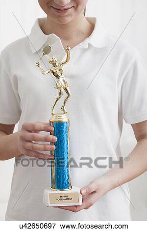 USA, Illinois, Metamora, Close up of girl (12-13) holding gold trophy View Large Photo Image Stock Photo - USA, Illinois, Metamora, Close up of girl (12-13) holding gold trophy . Fotosearch