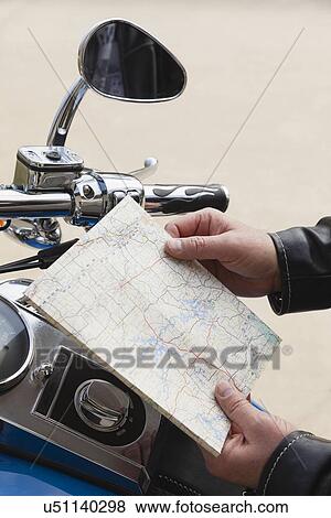 USA, Illinois, Metamora, Close up of man's hand holding map near motorcycle handlebars View Large Photo Image Stock Photo - USA, Illinois, Metamora, Close up of man's hand holding map near motorcycle handlebars. Fotosearch
