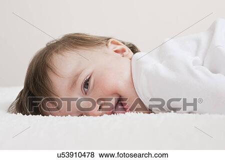 USA, Illinois, Metamora, close-up of smiling baby boy (12-17 months) lying on blanket View Large Photo Image Stock Photo - USA, Illinois, Metamora, close-up of smiling baby boy (12-17 months) lying on blanket. Fotosearch