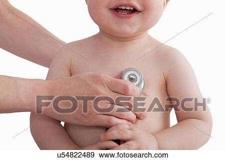 Stock Photo - USA, Illinois, Metamora, close-up of smiling baby boy (12-17 months) having medical exam. Fotosearch