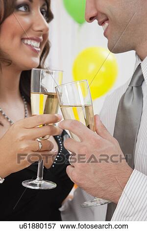 Stock Photo - USA, Illinois, Metamora, Close-up of couple toasting at New Year's Eve party. Fotosearch