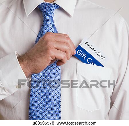 Stock Photo - USA, Illinois, Metamora, Close-up of man with Father's day gift card, mid section. Fotosearch