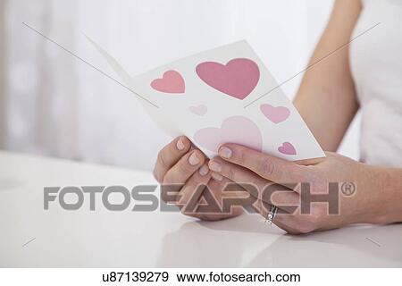 Stock Photo - USA, Illinois, Metamora, Close-up of woman's hands holding Valentine's card. Fotosearch