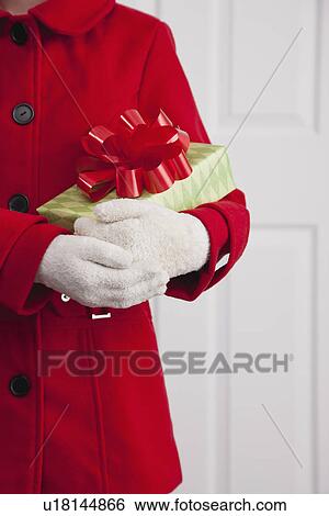 USA, Illinois, Metamora, Close up of girl (10-11) in red coat holding Christmas gift View Large Photo Image Stock Photograph - USA, Illinois, Metamora, Close up of girl (10-11) in red coat holding Christmas gift. Fotosearch