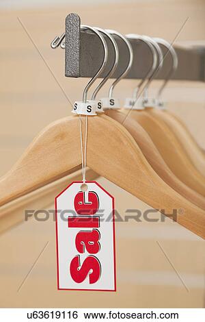 Stock Photograph - USA, Illinois, Metamora, Close-up of sale tag on empty hanger in shop. Fotosearch