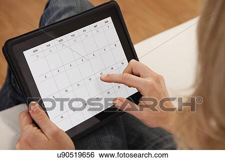 Stock Photograph - USA, Illinois, Metamora, Close-up of woman using calendar on digital tablet. Fotosearch