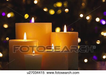 Stock Photography - USA, Illinois, Metamora, Close up of burning candles and Christmas lights in background. Fotosearch