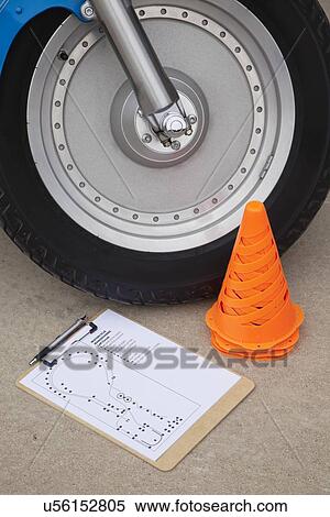 Stock Photography - USA, Illinois, Metamora, Close up of motorcycle wheel, traffic cone and test form. Fotosearch