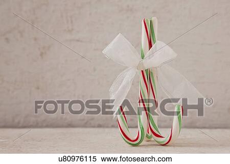 Stock Photography - USA, Illinois, Metamora, Close up of candy cane with ribbon. Fotosearch