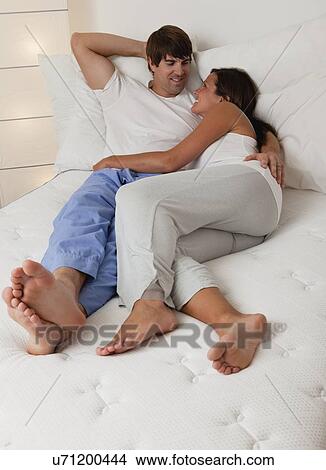 USA, Illinois, Metamora, couple lying down in bed and smiling face to face View Large Photo Image Picture - USA, Illinois, Metamora, couple lying down in bed and smiling face to face. Fotosearch