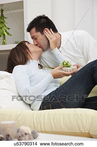 USA, Illinois, Metamora, Couple opening presents and kissing View Large Photo Image Picture - USA, Illinois, Metamora, Couple opening presents and kissing. Fotosearch