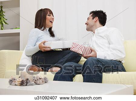 USA, Illinois, Metamora, Couple opening presents View Large Photo Image Stock Photo - USA, Illinois, Metamora, Couple opening presents. Fotosearch