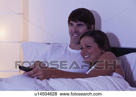 USA, Illinois, Metamora, couple watching TV in bed View Large Photo Image Stock Photo - USA, Illinois, Metamora, couple watching TV in bed. Fotosearch