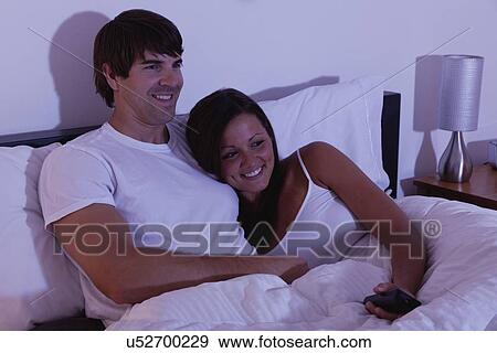 USA, Illinois, Metamora, couple watching TV in bed View Large Photo Image Stock Photo - USA, Illinois, Metamora, couple watching TV in bed. Fotosearch