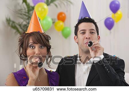 USA, Illinois, Metamora, Couple with noisemakers at New Year's Eve party View Large Photo Image Stock Image - USA, Illinois, Metamora, Couple with noisemakers at New Year's Eve party. Fotosearch
