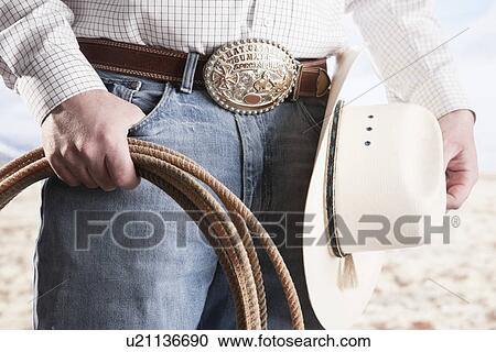 USA, Illinois, Metamora, Cowboy holding lasso and hat, mid section View Large Photo Image Stock Image - USA, Illinois, Metamora, Cowboy holding lasso and hat, mid section. Fotosearch